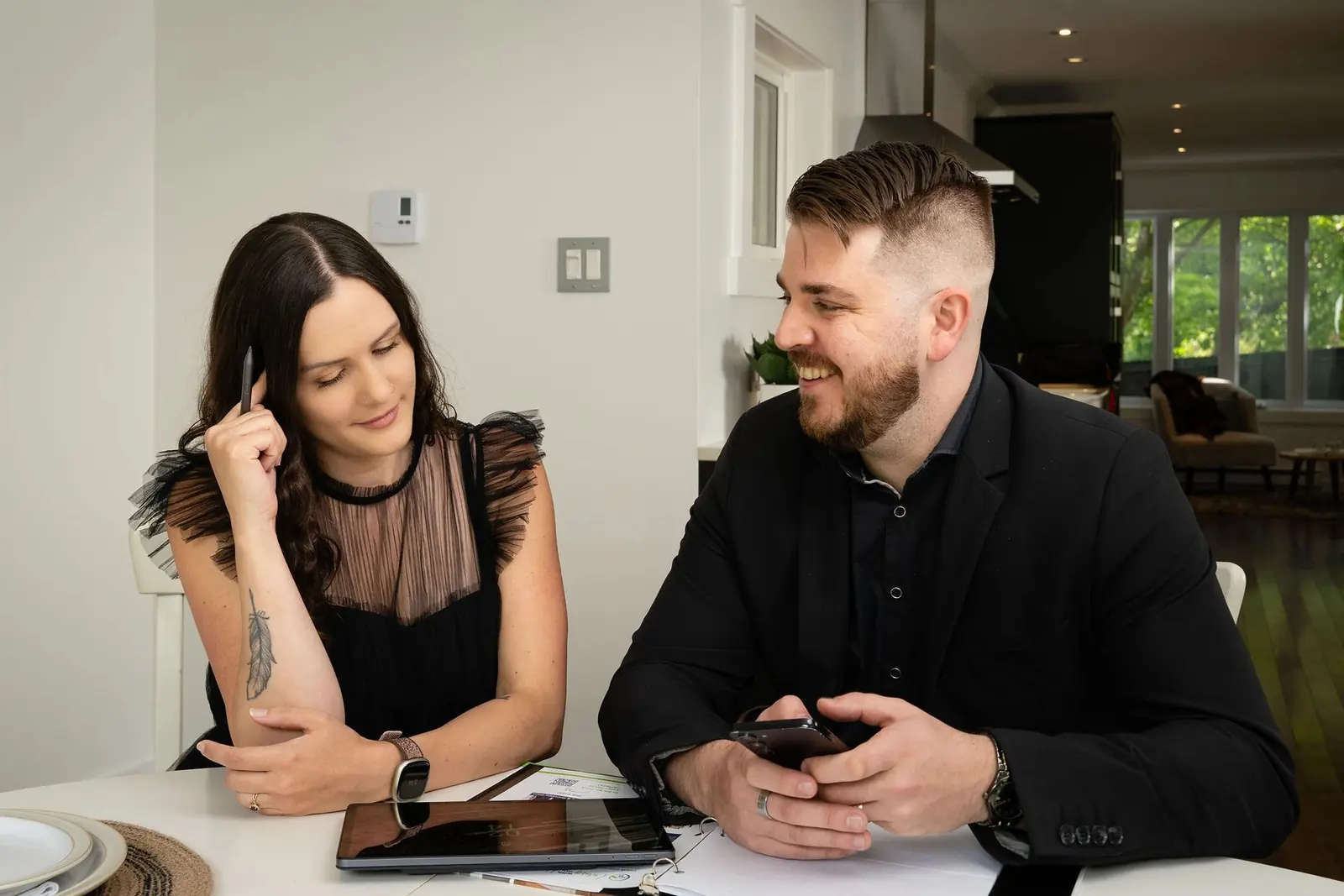 Natasha Sutherland and Tony Lucas, co-founders of L|S Real Estate Group, seated together at a table with a tablet and paperwork
